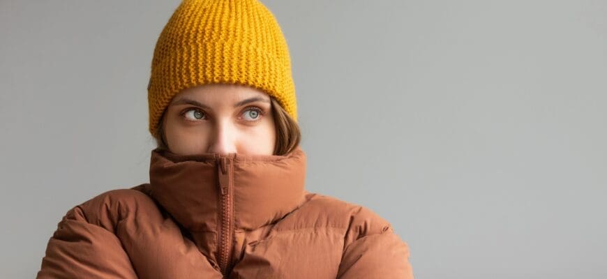 A,Woman,In,A,Warm,Jacket,And,Hat,Sits,On